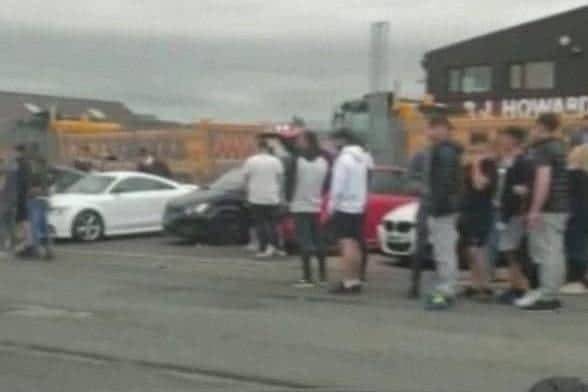 Crowds gather for a 'car meet' event in Lowfields Road in Leeds.