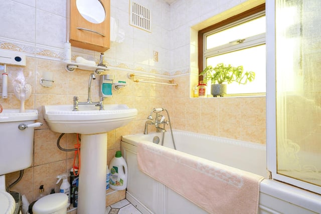 The family bathroom has a bath with a shower over, a toilet and a wash hand basin.