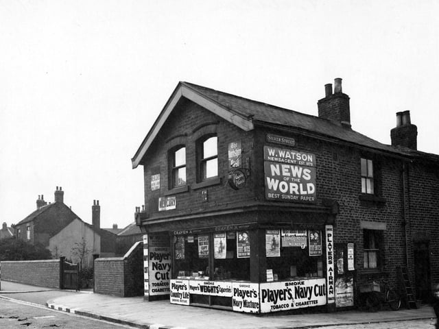 W. Watson newsagents on Town Street by the junction with Silver Street in August 1942. A boy in the foreground looks at the camera.