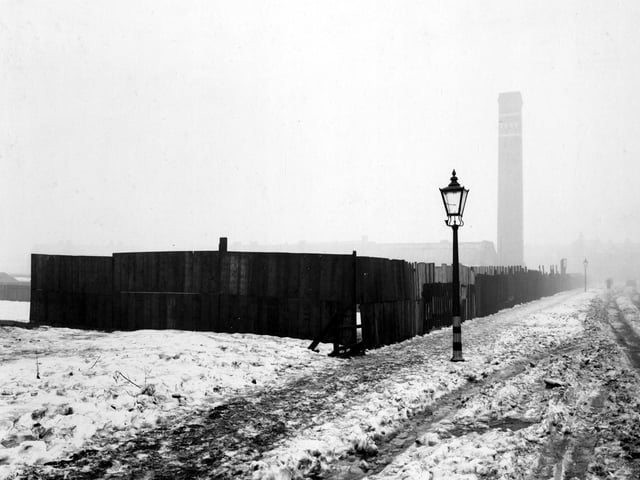 Snow on the ground with tyre tracks on Barkly Road in February 1940 . A large chimney, dated 1848, is in the distance.