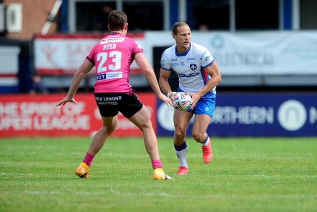 Trinity captain Jacob Miller takes on Wigan's Jai Field. Picture by James Hardisty.
