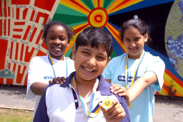 Students Sabina Adonteng, Asim Ali and Nafisah Iqbal show off the medals pupils were to receive when the school shuts its doors for the in July 2004.