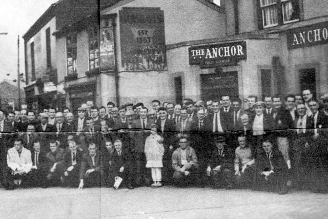 A group of men, taken outside the Anchor Inn in 1963. A young girl stands at the centre of the group on the front row. PIC: D. McGough