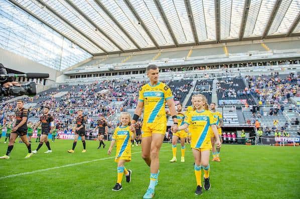 Maya and Macy Burrow lead Rhinos on to the field alongside captain Ash Handley. Picture by Allan McKenzie/SWpix.com.
