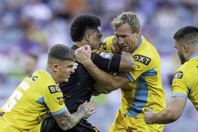 Castleford Tigers' Derrell Olpherts is tackled by Leeds Rhinos' Corey Johnson and Matt Prior. Picture: Allan McKenzie/SWpix.com