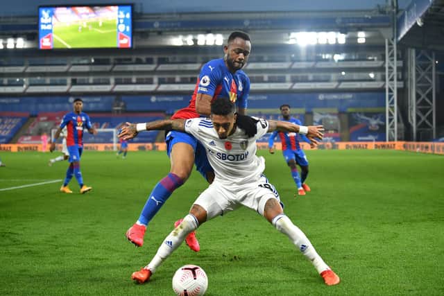 Raphinha holds off the challenge of Crystal Palace forward Jordan Ayew. Pic: Glyn Kirk.