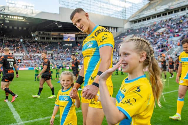 Rob Burrow's daughters Maya and Macy walk out with Ash Handley ahead of Leeds Rhinos' Magic Weekend game against Castleford. Picture: Allan McKenzie/SWpix.com.