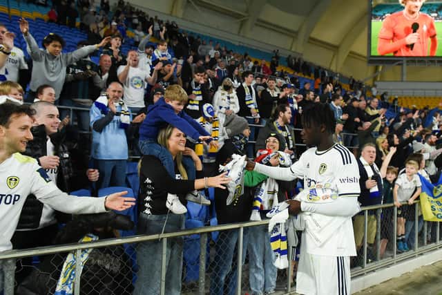 LEEDS ARE EVERYWHERE: Young midfielder Darko Gyabi with Whites scarves to hand out to delighted fans in the Cbus Super Stadium away end. 
Photo by Albert Perez/Getty Images.