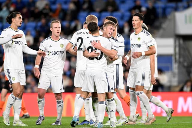 WINNING START: Joe Gelhardt, centre, hugs Dan James to celebrate putting Leeds United 2-0 up against Brisbane Roar. Photo by Bradley Kanaris/Getty Images.