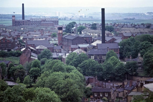 A telephoto shot taken from the clock tower of Morley Town Hall in June 1973. In the foreground are the trees and houses of Dawson Hill and Banks Hill, while the two mill chimneys are for two of the largest factories in Morley.