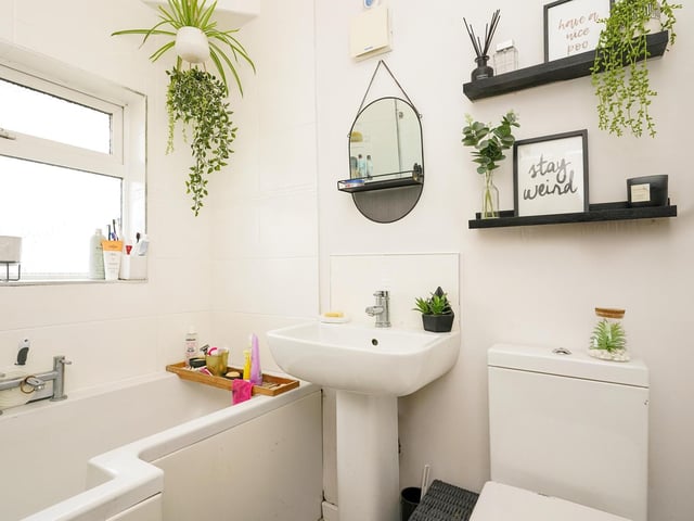 The modern white fitted bathroom suite has a bath with shower over, low flush toilet and a pedestal hand wash basin. There is also a heated chrome towel rail, extractor fan and a frosted window to the front elevation.