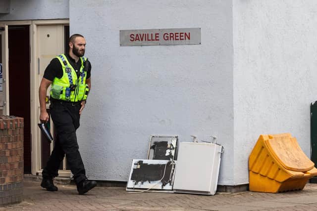 An officer leaving Saville Green flats, where the toddler died after falling from a window (Photo: SWNS)
