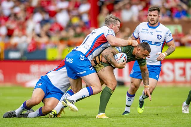 TOUGH CONDITIONS: Hull KR's Elliot Minchella tackled by Wakefields's Jai Whitbread and Matty Ashurst. Picture: Tony Johnson