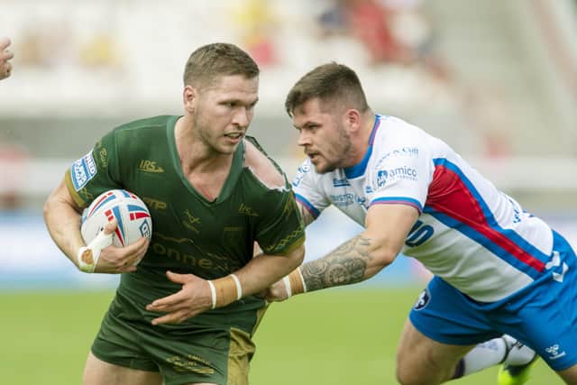 Hull KR's Matt Parcell looks for options as Wakefield's Liam Hood closes in. Picture: Tony Johnson