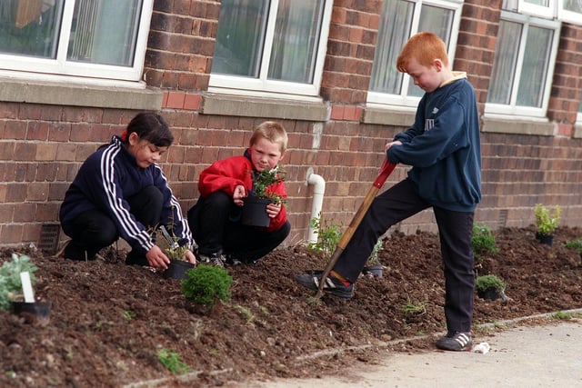 Windmill Primary pupils, from left, Stephen Driscoll, Jason Pepper and Nathan Clapham help to refurbish their school grounds in May 1998.