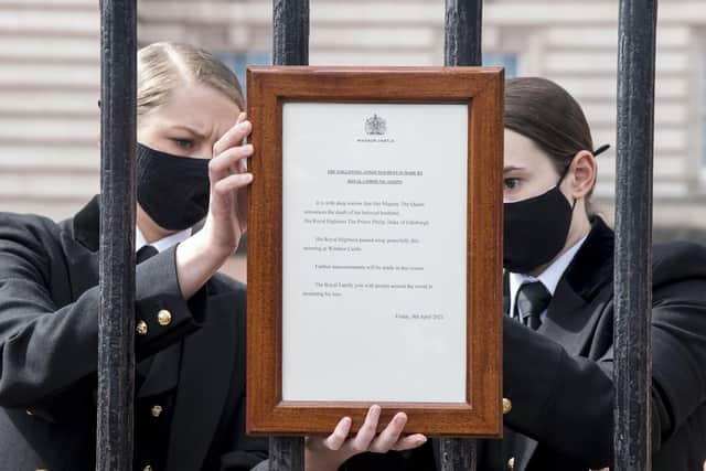 A sign announcing the death of the Duke of Edinburgh, who has died at the age of 99, is placed on the gates of Buckingham Palace.