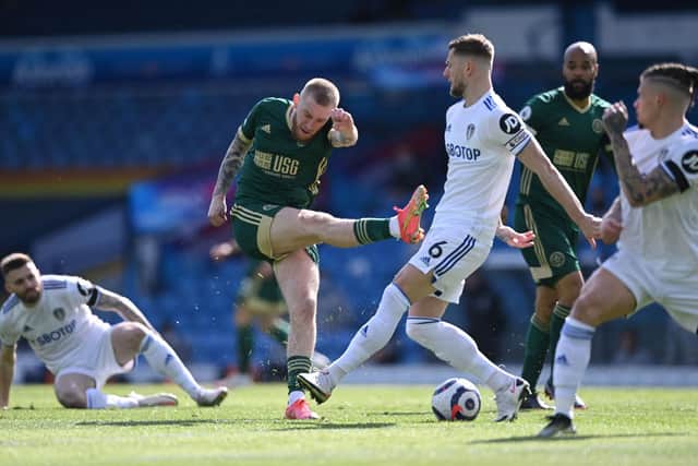 TOP OF THE BLOCKS: Leeds United captain Liam Cooper, right, stops a shot from Oli McBurnie upon his return to the Whites side in last weekend's 2-1 victory against Sheffield United. Photo by LAURENCE GRIFFITHS/POOL/AFP via Getty Images.