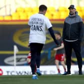 Liverpool manager Jurgen Klopp looks on as a Leeds United player warms up on the pitch wearing a shirt opposing the new European Super League ahead of the Premier League match at Elland Road