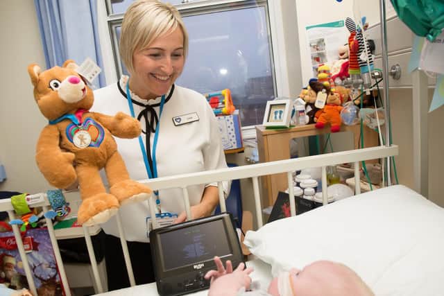 Lisa from Leeds Congenital Heart Unit handing out a Katie bear teddy to baby Oscar.