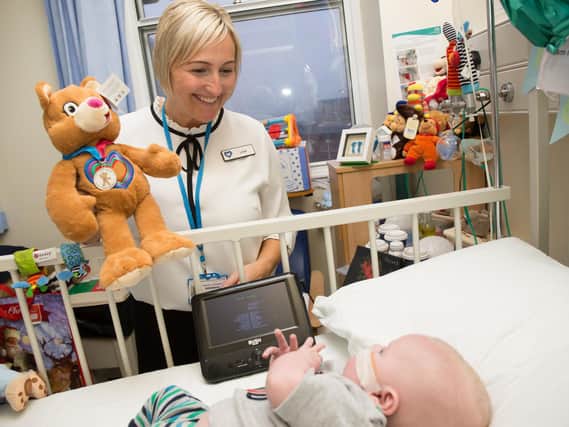 Lisa from Leeds Congenital Heart Unit handing out a Katie bear teddy to baby Oscar.
