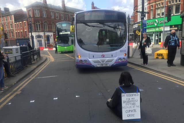 A woman sits in the road in Call Lane, Leeds (photo: Maya Jagger).