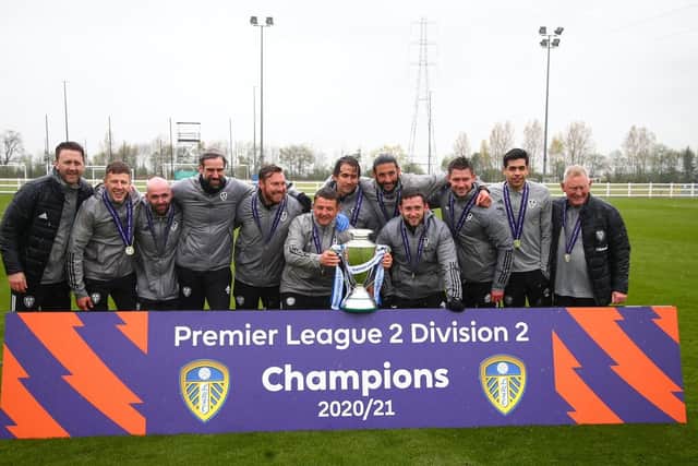 CHAMPIONS RAIN: Mark Jackson and his team of coaches get their hands on the Premier League Two Division Two trophy after a completing a stunning season with Leeds United's under-23s. Picture by LUFC.