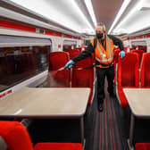 Library image of a cleaner using a fogging machine to clean a train carriage during the night