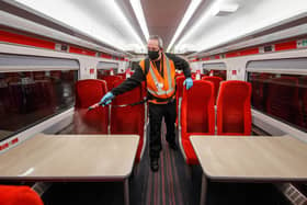 Library image of a cleaner using a fogging machine to clean a train carriage during the night