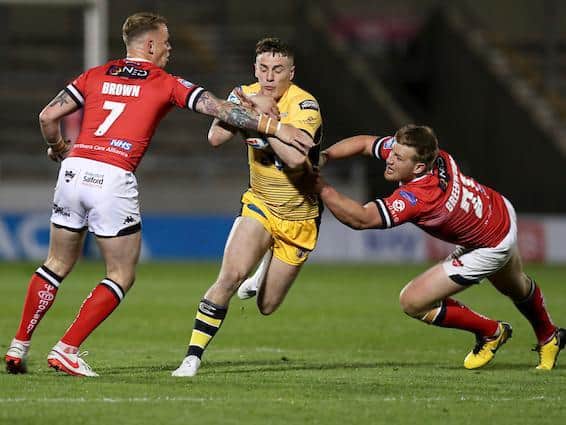 Tigers' Jake Trueman is tackled by Salford's Kevin Brown and James Greenwood during last week's match. Picture by Paul Currie/SWpix.com.