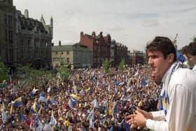 Eric Cantona looks out onto a sea of fans during a civic reception for Leeds United after winning the First Division title.