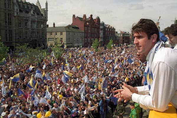 Eric Cantona looks out onto a sea of fans during a civic reception for Leeds United after winning the First Division title.