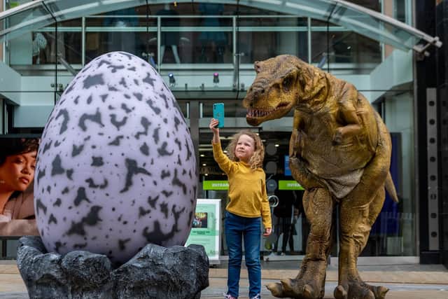 Five-year-old Agnes Gacquin meets one of the dinosaurs. PIC: James Hardisty