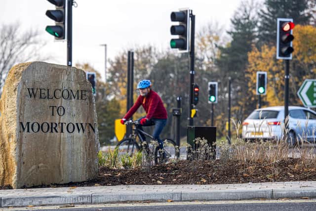 Person cycling past Welcome to Moortown sign. Photo: Leeds City Council
