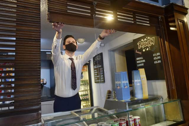 Gary Benn, manager of Cottage Road Cinema brings up the shutters for reopening. Picture: Steve Riding.