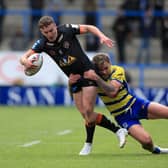 HELD BACK: Castleford Tigers' Jacob Trueman (left) is tackled by Warrington Wolves' Blake Austin at the Halliwell Jones Stadium. Picture: Mike Egerton/PA