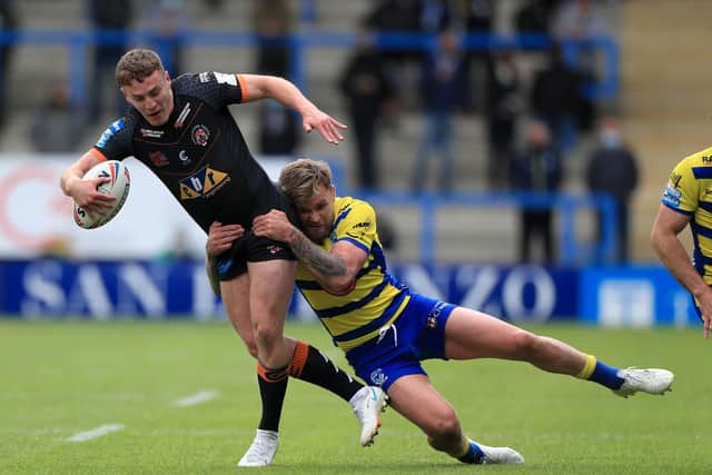 HELD BACK: Castleford Tigers' Jacob Trueman (left) is tackled by Warrington Wolves' Blake Austin at the Halliwell Jones Stadium. Picture: Mike Egerton/PA