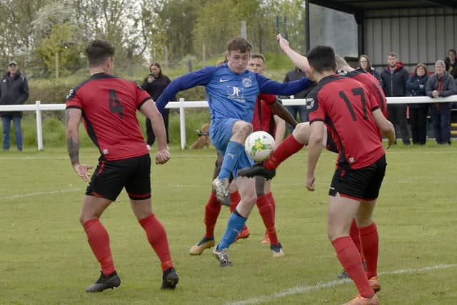 Alex Ingham, of Boroughbridge, is crowed out by Horbury Town defenders. Picture: Steve Riding.