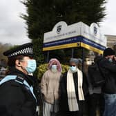 A police officer observes protesters gathered outside Batley Grammar School in Batley, West Yorkshire, where a teacher was suspended for reportedly showing a caricature of the Prophet Mohammed to pupils during a religious studies lesson in March. Photo credit:  Danny Lawson/PA Wire