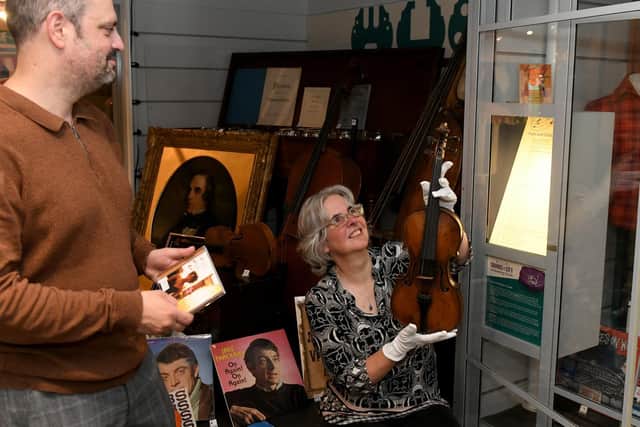 Patrick Bourne, assistant curator of Community History with a Corinne Bailey Rae CD, and Kitty Ross, curator of Leeds History, with a Joseph Dearlive violin, one of the oldest and newest exhibits in the Sounds of The City exhibition at Abbey House Museum.