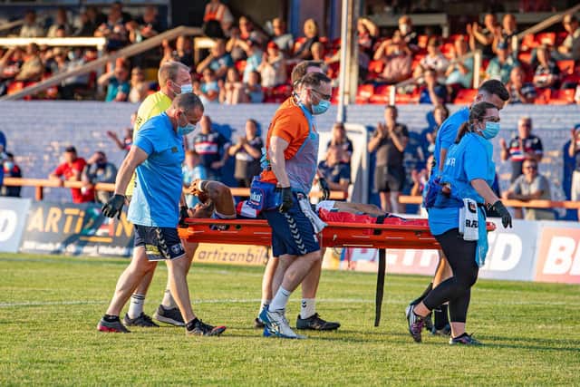 Trinity's Bill Tupou is taken from the field on a stretcher after suffering a knee injury. Picture by Tony Johnson.