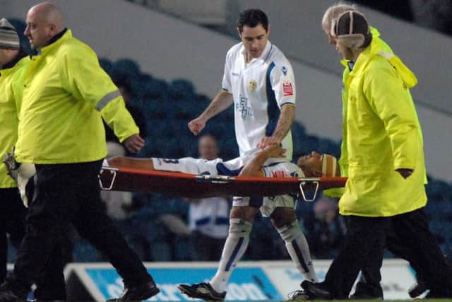 Andy Hughes talks to Patrick Kisnorbo after he was stretchered off during Leeds United's clash with Millwall at Elland Road in March 2010.