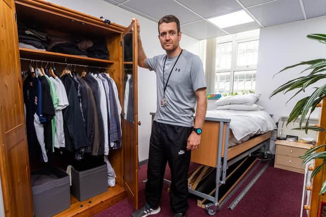 James Paylor in the makeshift bedroom set up that teaches students how to fold and put away clothes, make and change a bed and other household duties.