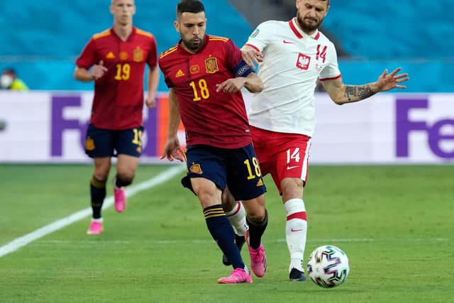 STILL IN IT: Leeds United midfielder Mateusz Klich, right, battles it out with Spain's Jordi Alba in Saturday's 1-1 draw in Seville. Photo by THANASSIS STAVRAKIS/POOL/AFP via Getty Images.