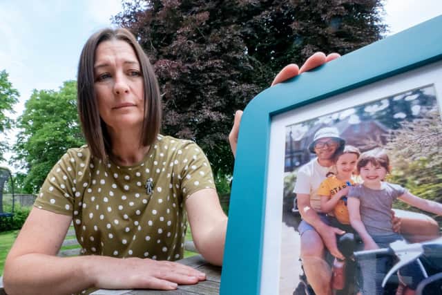 Tina Pinder, with a photo of her late husband Lloyd Pinder and their two children Gracie (second right), 12 and Lola (right), 8, at her home in South Milford, North Yorkshire (photo: PA Wire/ Danny Lawson)