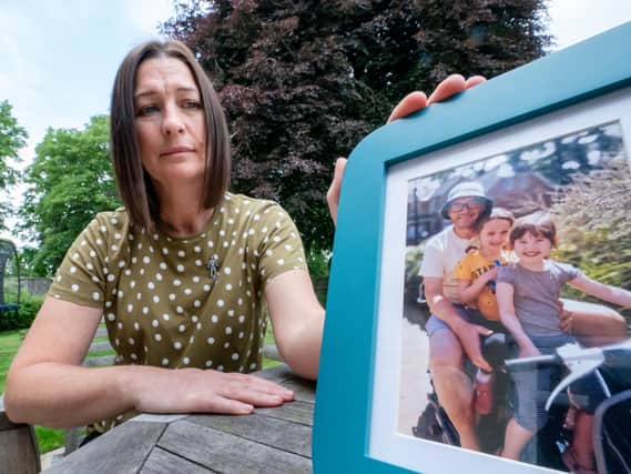 Tina Pinder, with a photo of her late husband Lloyd Pinder and their two children Gracie (second right), 12 and Lola (right), 8, at her home in South Milford, North Yorkshire (photo: PA Wire/ Danny Lawson)