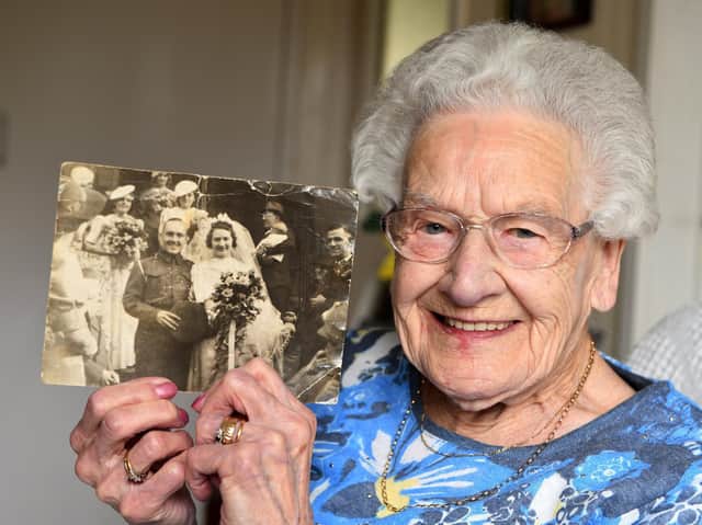 Centenarian Constance Stead holding a photo of her and late husband Wilfred on their wedding day on September 27 1941.