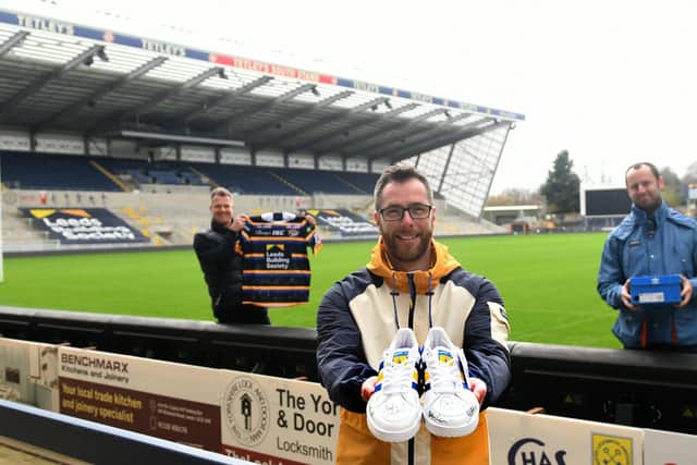 Craig Chapman (centre ) from The Pool pictured in November 2020 with the unique custom Rob Burrow Trainers for the MND charity with Rob Oates from the Leeds Rhinos with a signed Rhinos shirt (left) and Craig's friend David Mills.