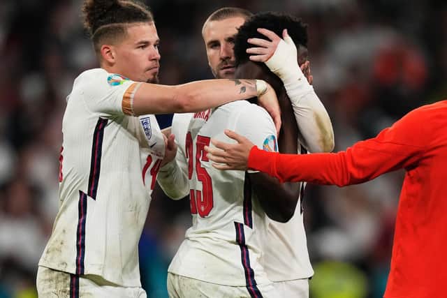 England players comfort Bukayo Saka at Wembley. Pic: Getty
