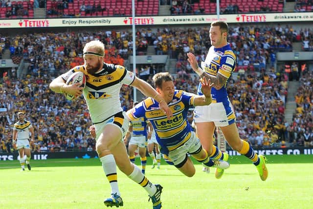 Oliver Holmes gets past Danny McGuire and Zak Hardaker to score for Tigers against Leeds at Wembley in 2014. Picture by Steve Riding.
