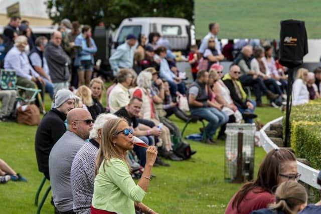 Visitors to the first day of the show relax in the fine weather to watch the showjumping in the main ring. Picture Tony Johnson.